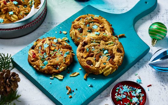 A few Santa trash cookies on a board and a few in a cookie tin