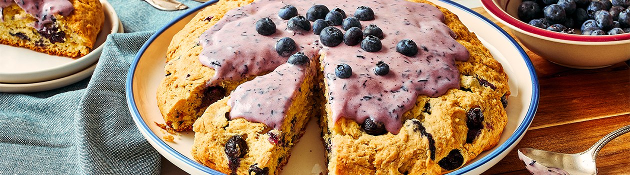Blueberry bannock with cream cheese icing on a white plate.