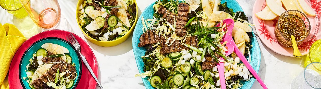 Three portions of bulgogi smashed burger salad on a marbled surface.