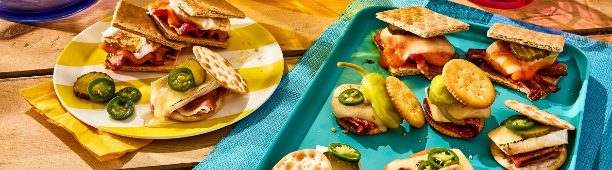 Collection of savoury smores on plates - charcuterie smores, pickle and melty brie, and double cheese and bacon.