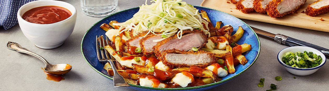 A bowl with the Japanese Tonkatsu Poutine, a cutting board with slices of the pork cutlet, a bowl of green onion, and another bowl of the tonkatsu-style gravy.